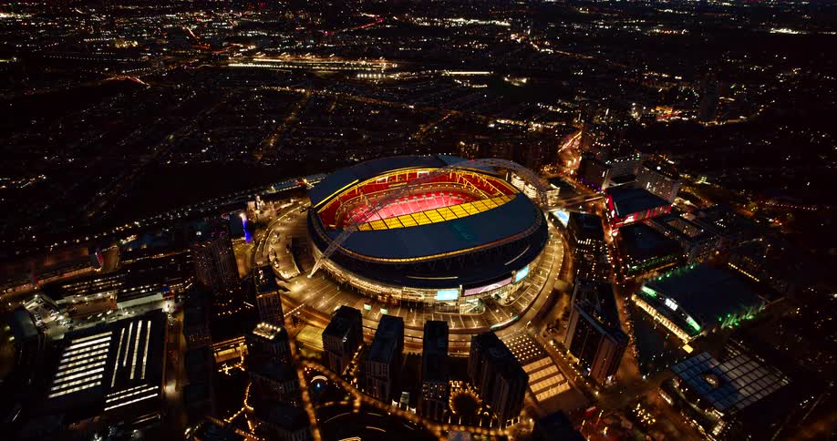 Aerial of a lit sports stadium in a metropolitan city at night