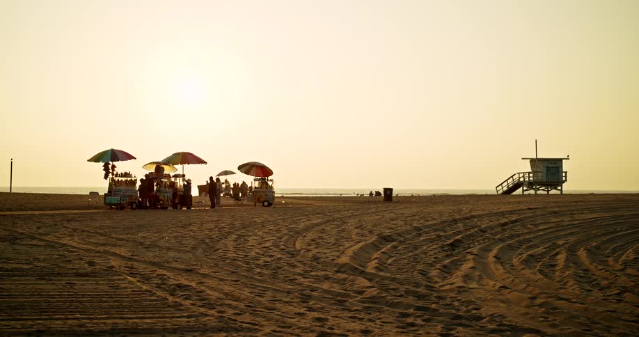Colorful food stalls on the beach during sunset