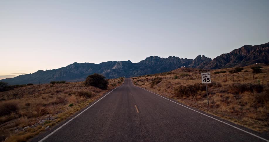 Traveling on a rural highway road with mountains in the distance