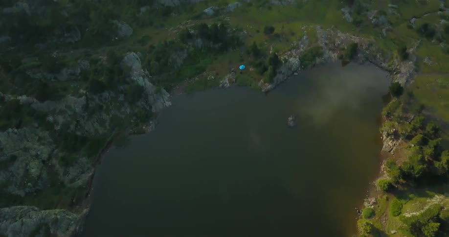 Aerial view of a lake surrounded by grass and trees