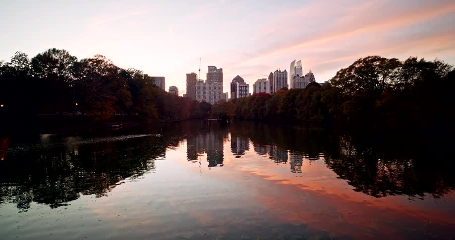 A view of a river in front of the buildings of a large city at sunrise