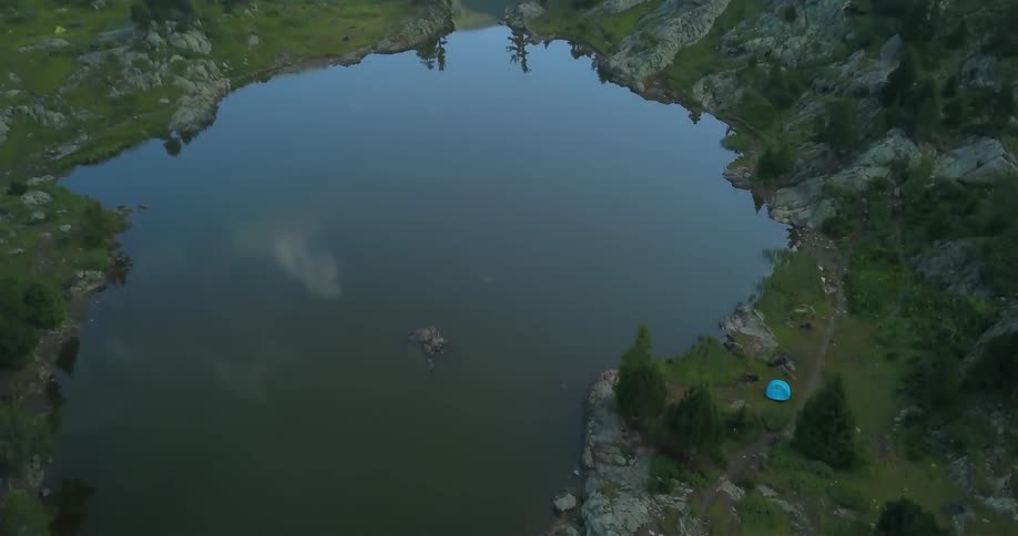 Blue tent next to small lake in wilderness