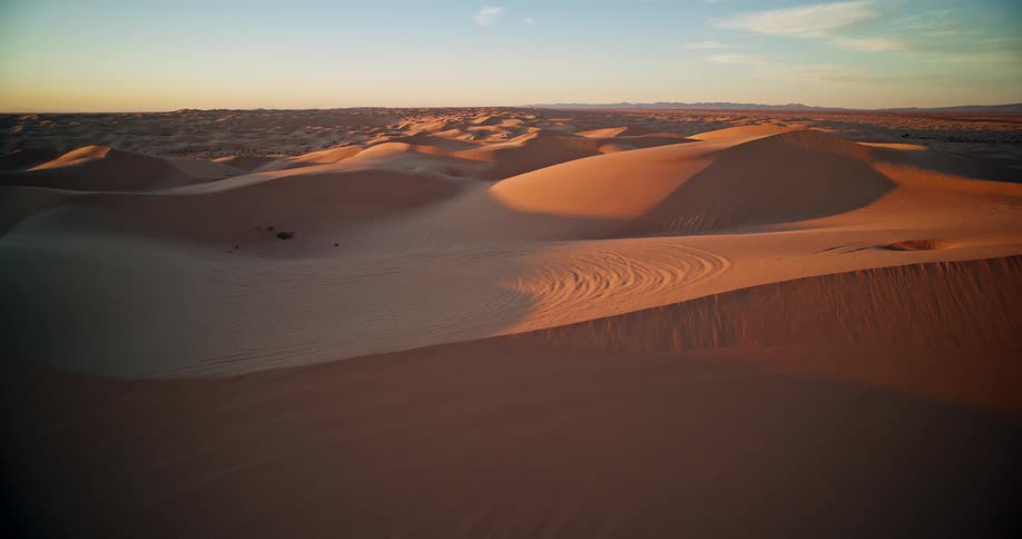 Aerial of sand dunes in a desert at sunset