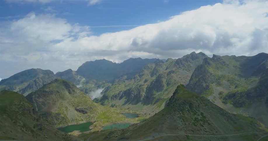 A long range of mountains has heavy clouds in the distance