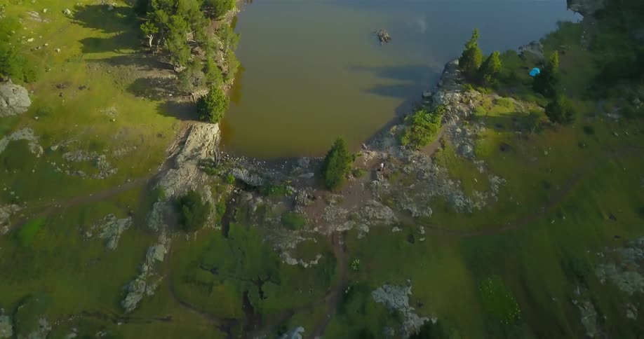 The green fields lead to a pond and a mountain