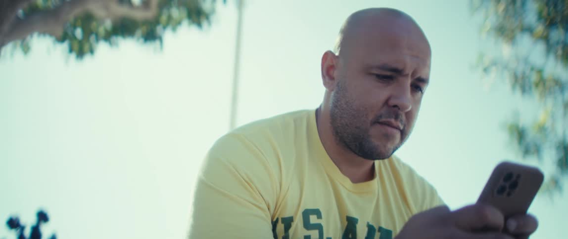 Close up of a man using a mobile phone while sitting outdoors during daytime