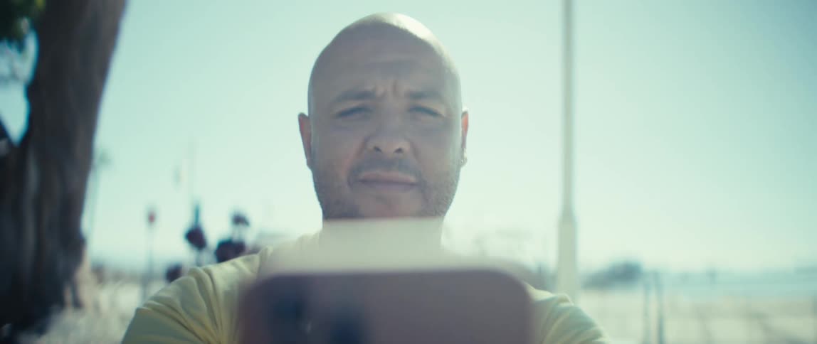 A man nods as he looks at his cellphone