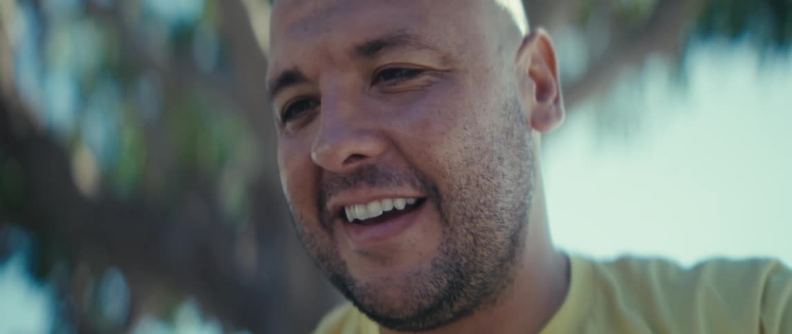 A man waving while on a mobile video call outdoors during daytime