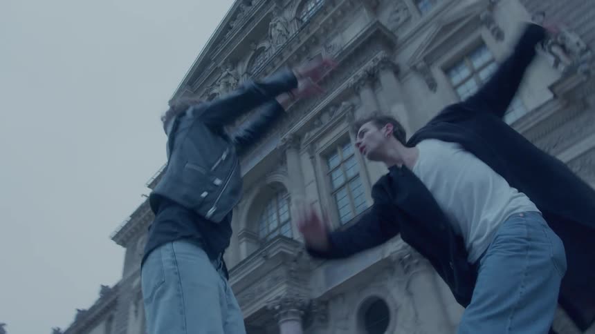 A man and woman are dancing outside an old building