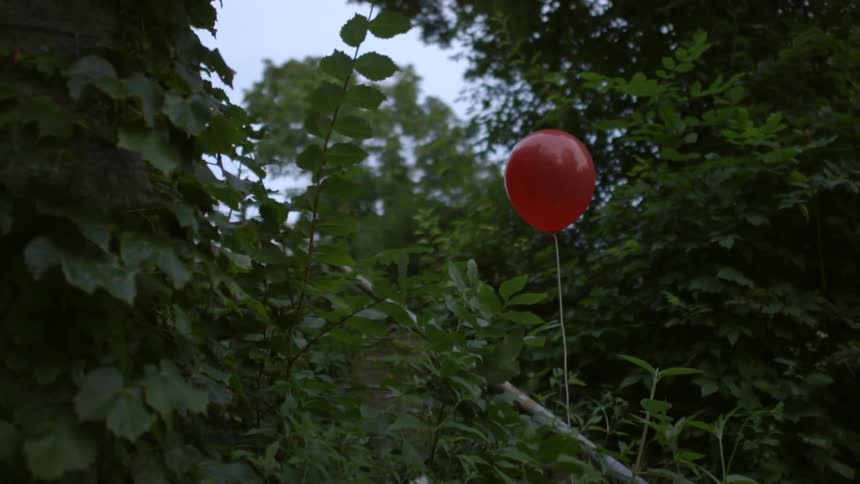 A red balloons floats on the steps