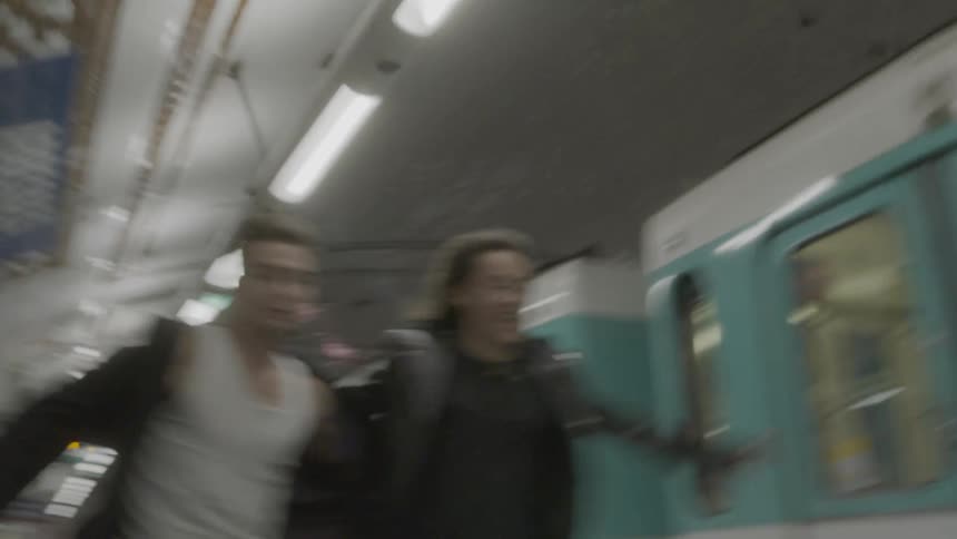 A man and woman running outdoors next to a train