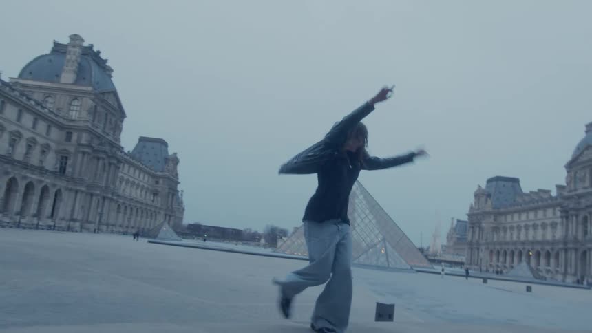 Woman and a man dancing in a public square on a cloudy day