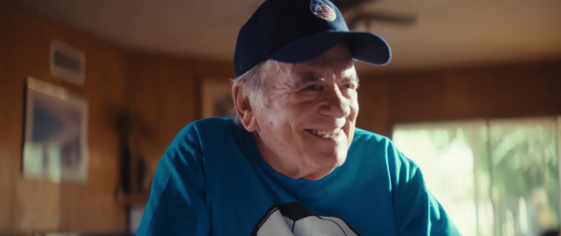 The man is having fun watching a sports game on the television