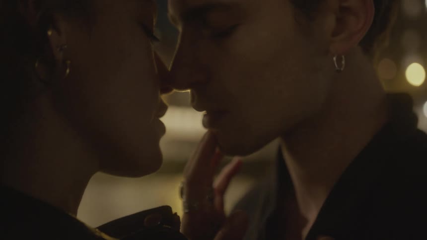 A young couples faces as they kiss and caress each other