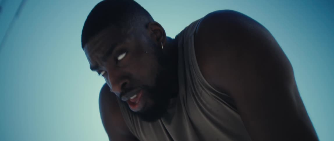 Bearded black man panting and then looking ahead with a determined face expression outdoors during day time