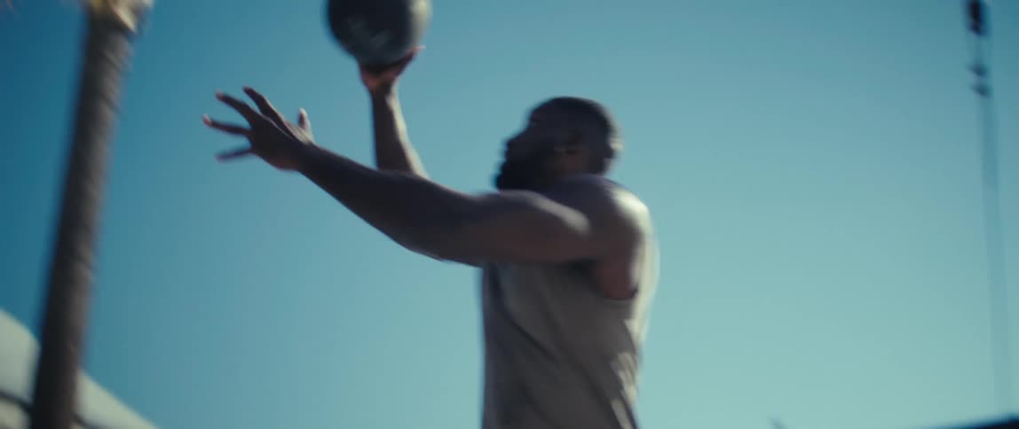 Man making a basket in an outdoor basketball game