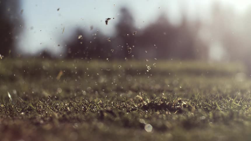 Golf club striking the ball and lifting dirt and grass