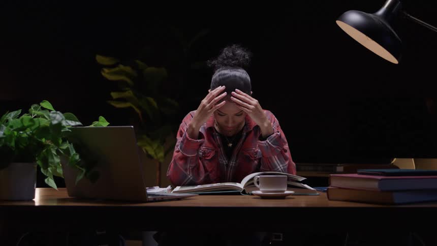 Tired student struggles to stay focused while studying late at night