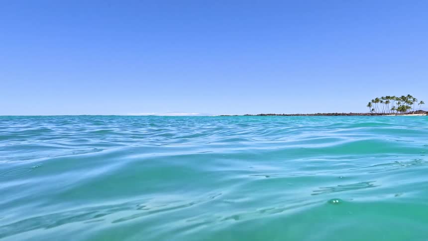 Calm waves reflect the blue sky on a sunny day