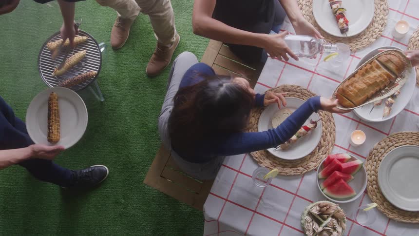 People share food at an outdoor barbecue