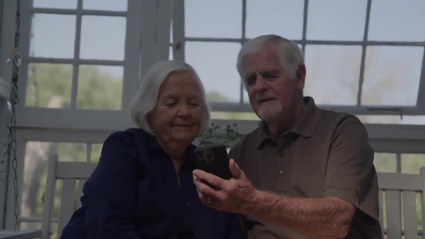 A man and woman looking at a smart phone