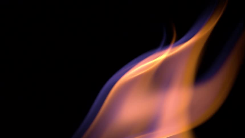 An orange flame moving across a black background