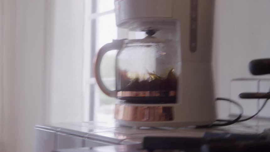 Coffee pot shakes wildly and coffee inside splashes during an earthquake