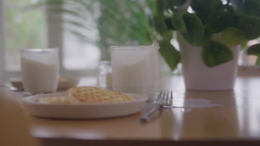 Breakfast plates on a table shake and milk spills during an earthquake