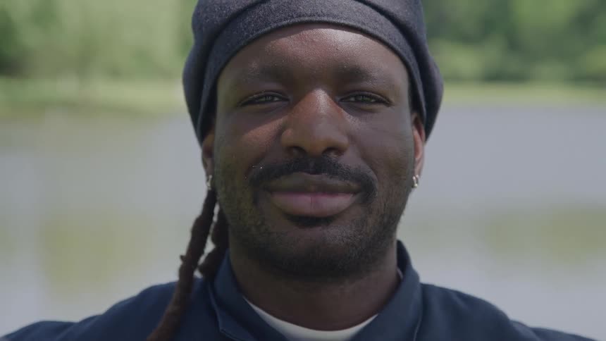 Close up portrait of a young happy black man outdoors during daytime