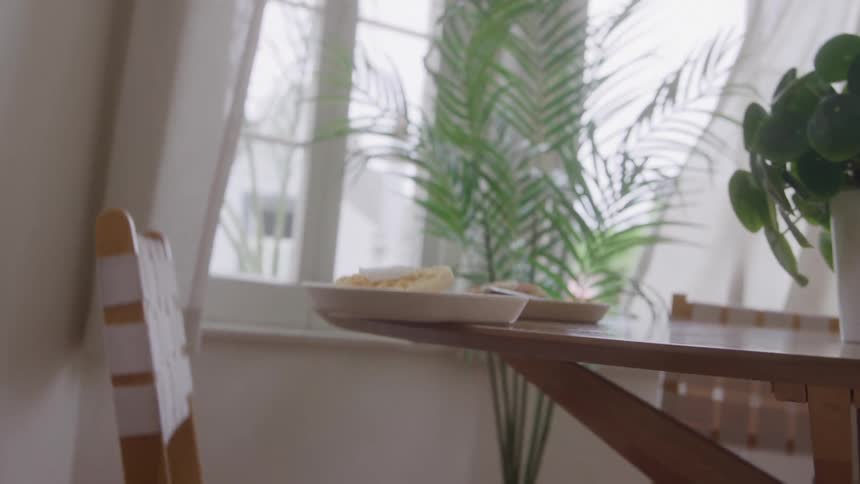 A white plate on a table is falling due to an earthquake affecting the area