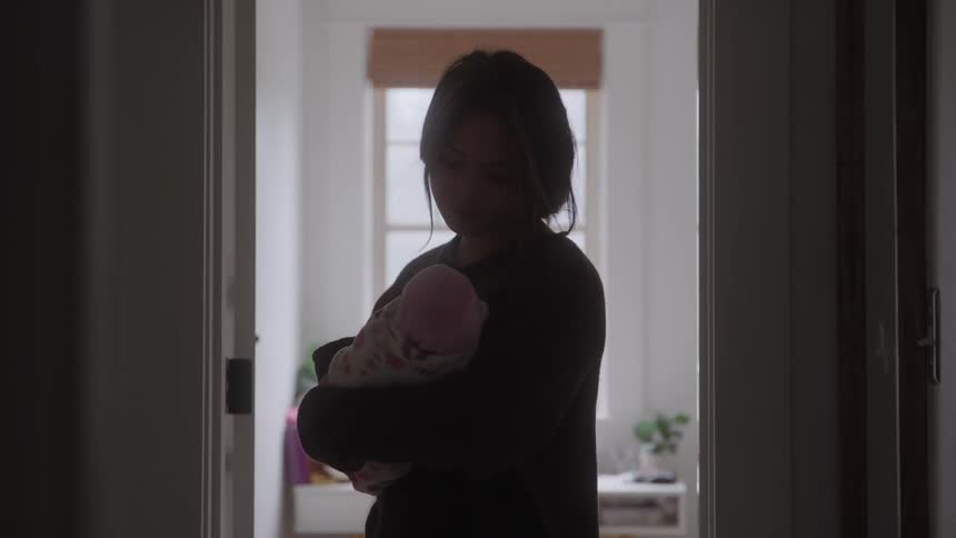 The mother is rocking her baby