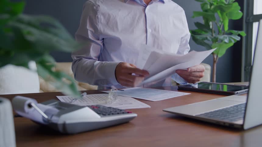 Man doing paperwork at a desk gets frustrated