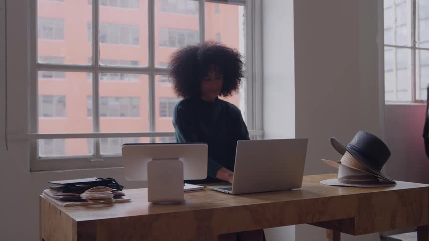 A woman is typing on a laptop in a retail store
