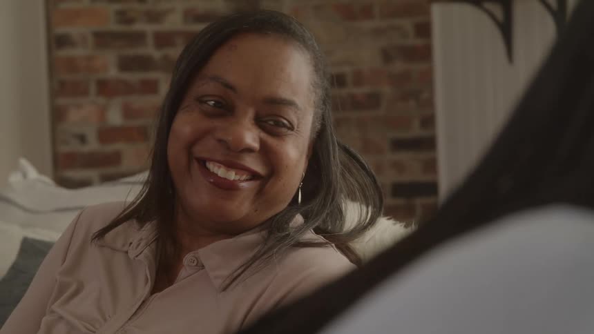 The face of a woman who is talking to someone in front of her and she is smiling