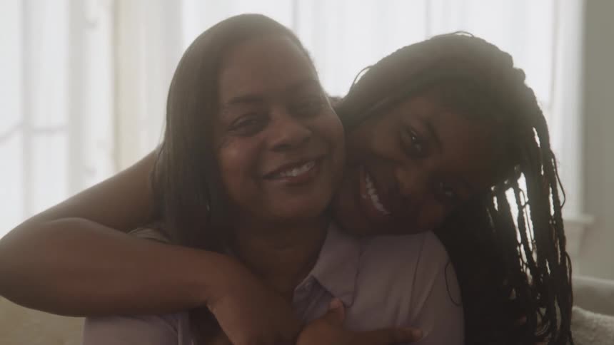 Mother and daughter hugging with warm smiles