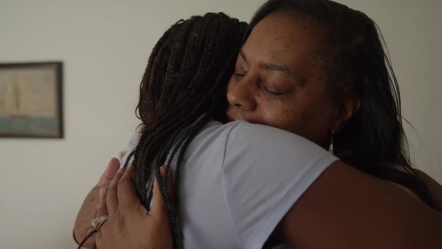 Two women one older and one younger share a long and tender hug