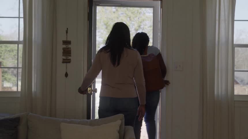 Mother and daughter saying goodbye and leaving through the front door