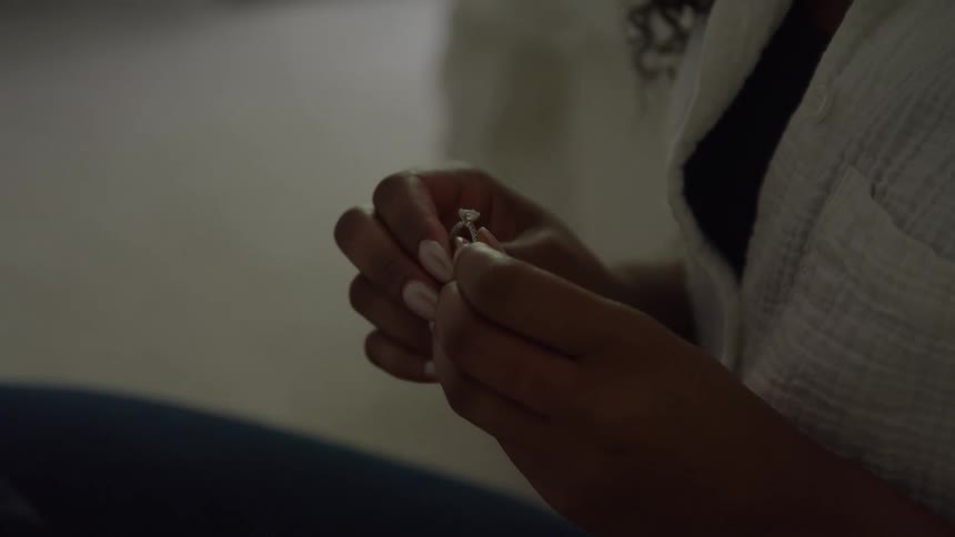 A person holds and examines a diamond ring in their hands