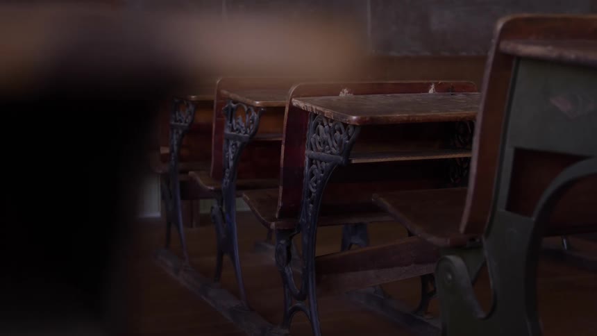 Old school desks aligned in an empty classroom