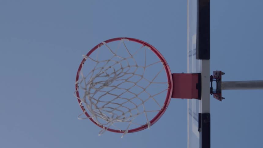 A basketball falls through the hoop