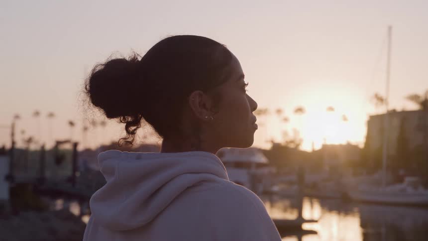 Woman watching the sunset near the dock