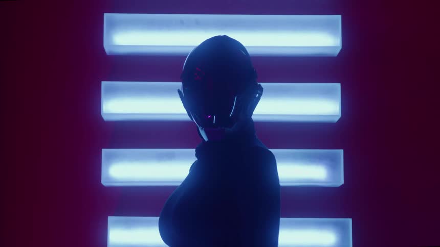 A silhouetted figure in a futuristic helmet stands in profile against a wall of glowing blue horizontal lights