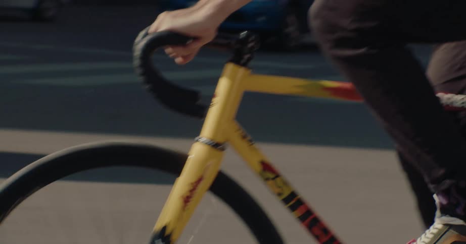 The man rides his bicycle past the man driving a car