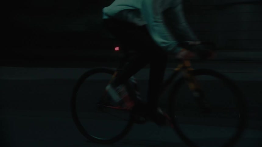 The man rides under the dark overpass