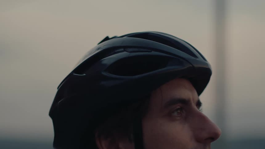 Man looks toward the horizon wearing a black cycling helmet