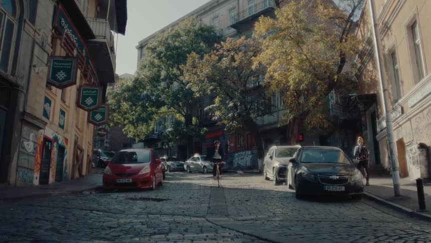 A man on a bicycle going down a stone road in a city