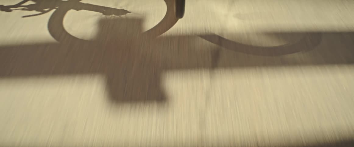 Bicycle moving along the road casts a shadow during the daytime