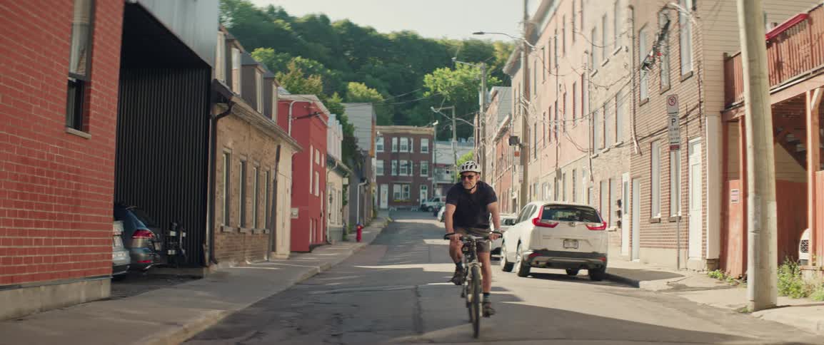 A man rides his bike down a historic town road