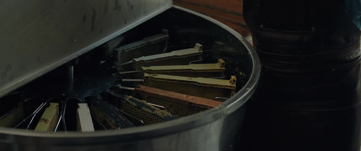 Man working in a distillery places a honeycomb tray into a centrifuge machine