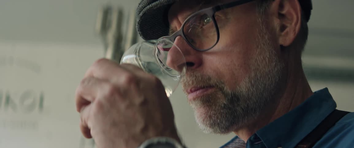 Man holds a glass of alcohol under his nose to test smell